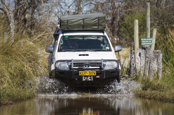 Four-wheel car crossing a river