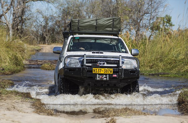 Four-wheel car crossing a river