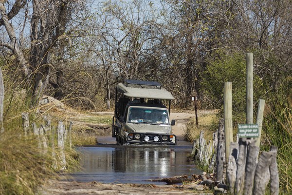 Four-wheel car crossing a river