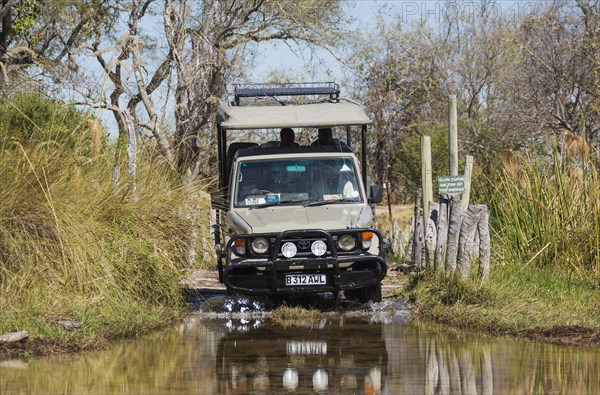 Four-wheel car crossing a river