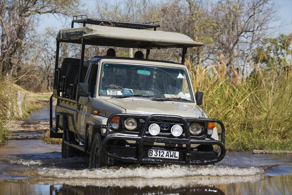 Four-wheel car crossing a river