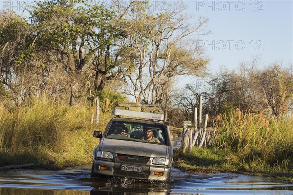 Four-wheel car crossing a river