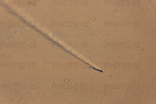 A vehicle of the balloon ground crew crossing a sandy plain at the edge of the Namib Desert