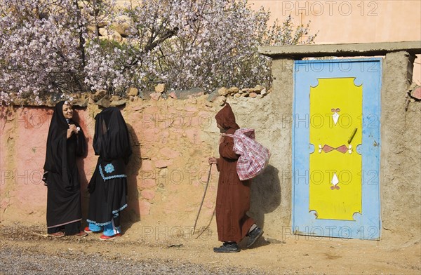 Chatting Berber women in front of a wall