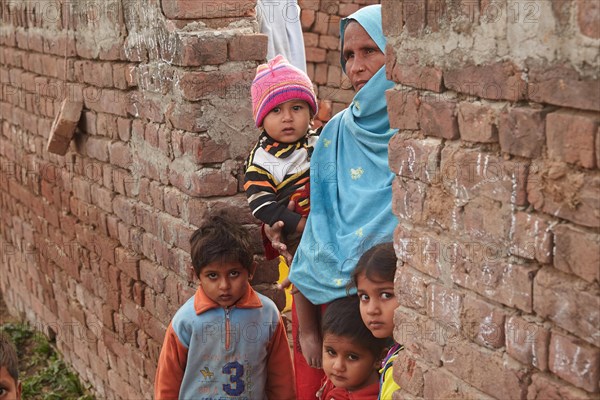 Mother with children living in a brickyard