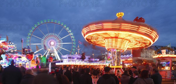 Ferris wheel with swing caroussel at dusk