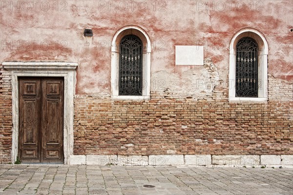 Red house wall with windows and doors in the San Polo district