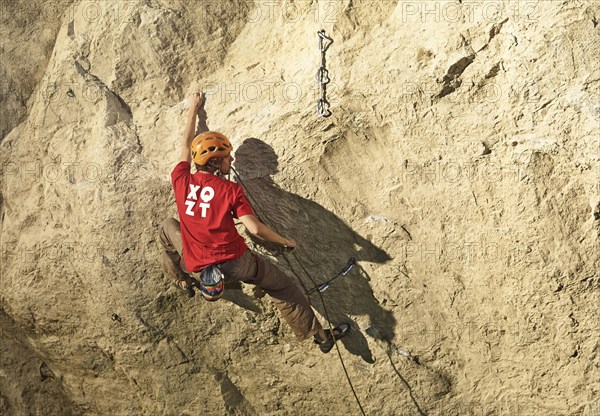 Climber lead climbing on a rock face