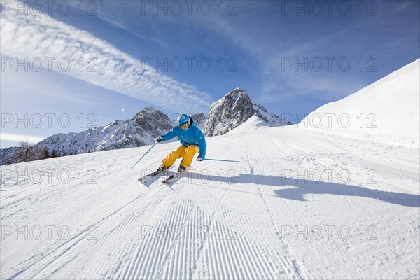 Skier with a helmet skiing down a slope