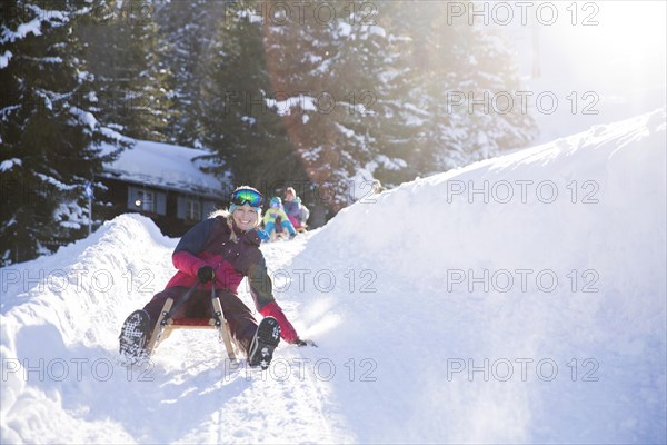 Young woman riding a sledge