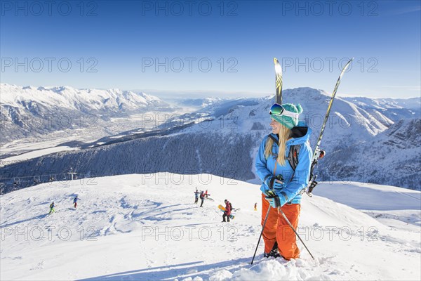 Young woman with skis enjoying the view