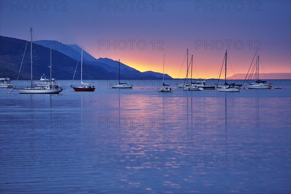 Sailing boats in harbour at sunset