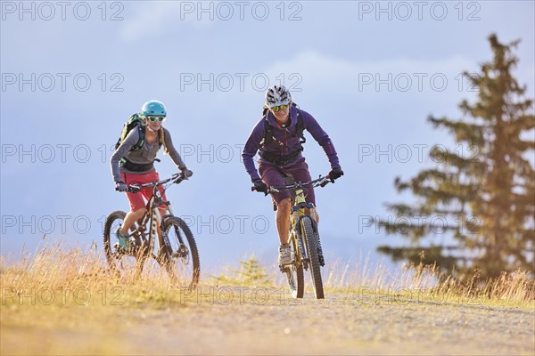 Two mountain bikers with helmets riding on gravel roads