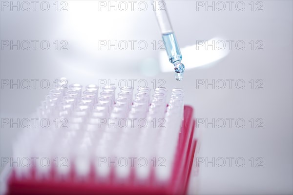 Blue liquid dripping from pipette into test tube