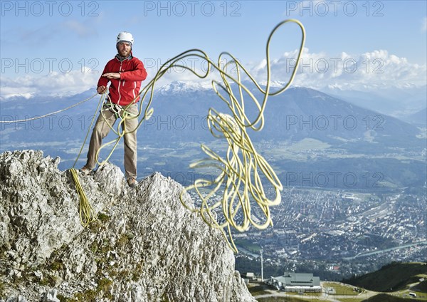 Climber on rock throwing a climbing rope