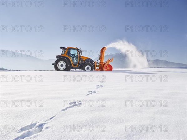 Tractor with a snow blower clearing snow