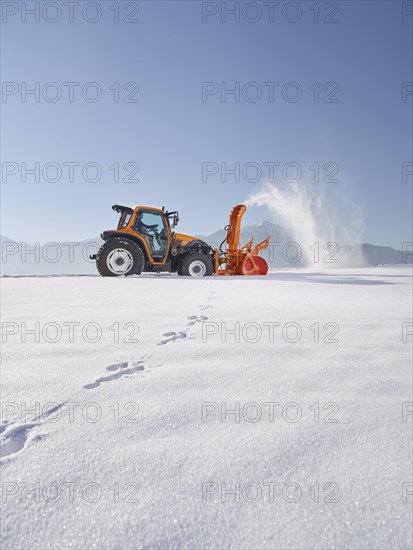 Tractor with a snow blower clearing snow