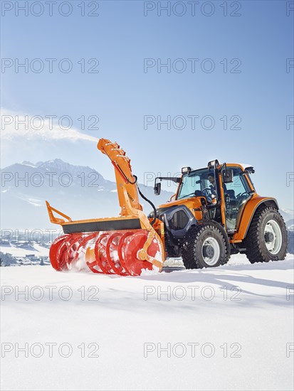 Tractor with a snow blower clearing snow