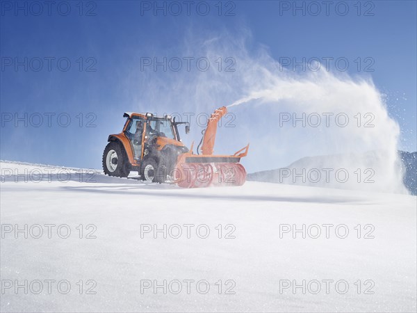 Tractor with a snow blower clearing snow