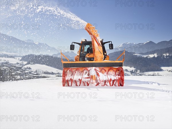 Tractor with a snow blower clearing snow