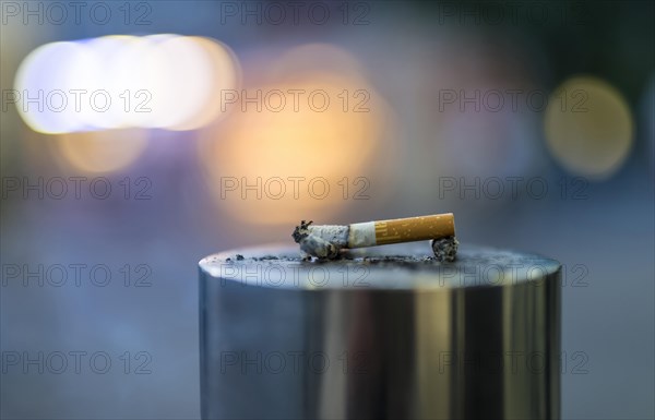 Discarded cigarette butt on metal post