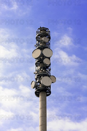 Transmission tower against cloudy sky