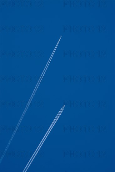 Contrails of two aircrafts in a blue sky