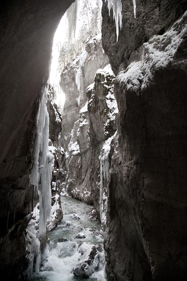 Icy gorge with a mountain stream and steep rock walls