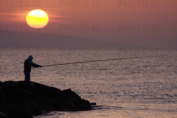 Angler in the backlight at dawn