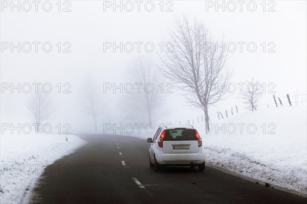 Car on a country road in a snow-covered landscape