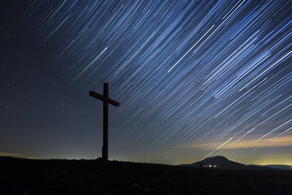 Summit cross on Bisberg Mountain with a starry sky