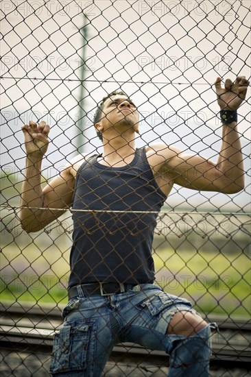 Young man climbing a fence