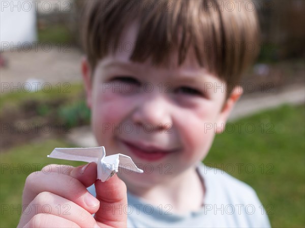 Child holding a paper airplane