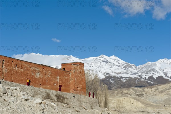 Red wall of a building with monks