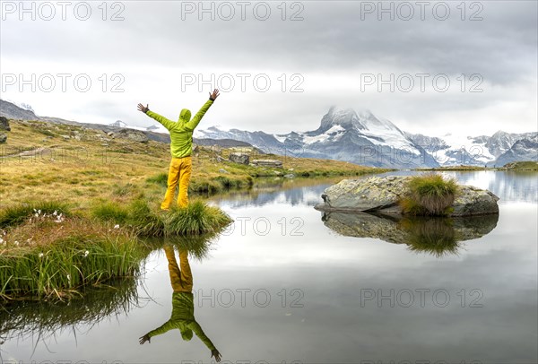 Hiker stretches his arms into the air