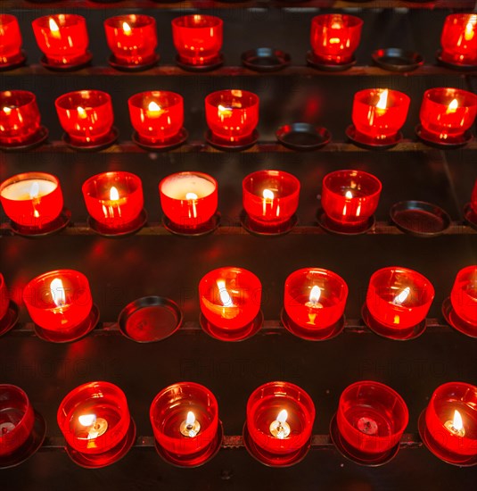 Burning votive candles in a church