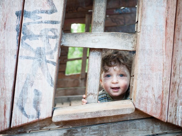 Toddler looking out of a playhouse