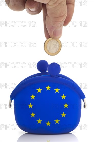 Hand dropping a euro coin in a blue purse with euro-stars