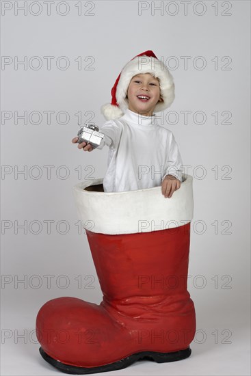 Boy with small gift in a Christmas boot