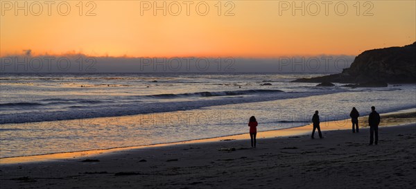 People at sunset at the Pacific beach of Cambria