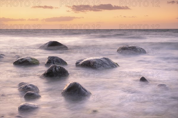 Stones washed by waves on the Baltic coast in the evening light