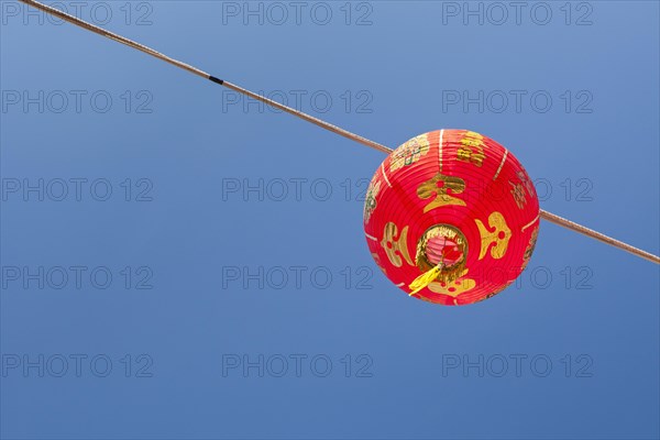 Red Chinese New Year lantern against blue sky