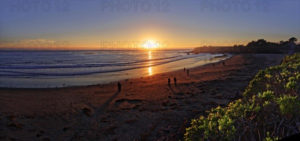 People at sunset at the Pacific beach of Cambria