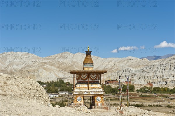 Colourfully decorated Buddhist stupa at the entrance to the village