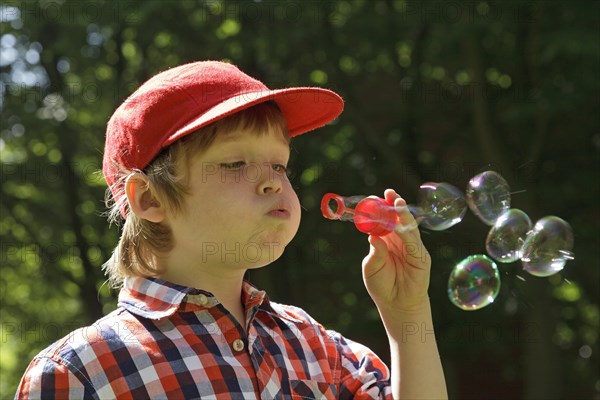 Boy blowing soap bubbles
