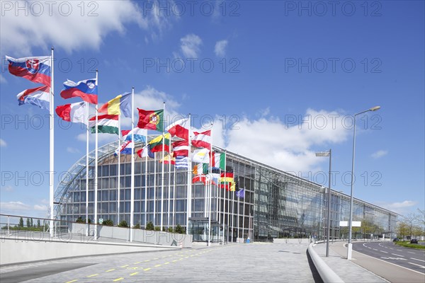 International flags waving in front of European Investment Bank