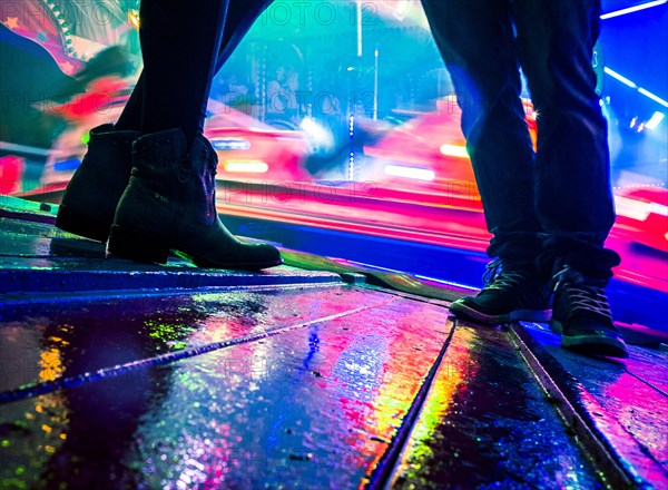 Legs of two people at a funfair