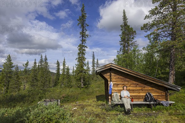 Woman resting at a wind shelter and campsite