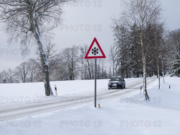 Traffic sign at a snow-covered road in winter