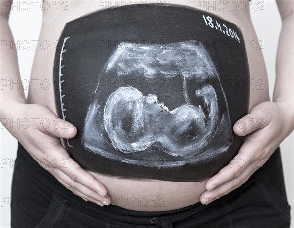 Pregnant woman with a body paint of an ultrasound image on her belly